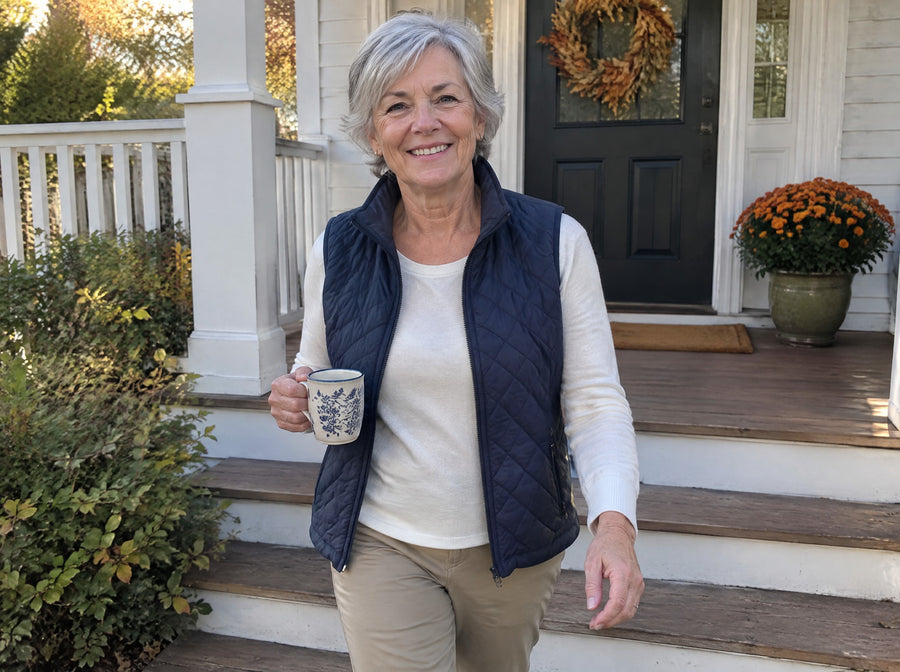 A woman in her 60s walking down her porch steps with an easy stride in morning light